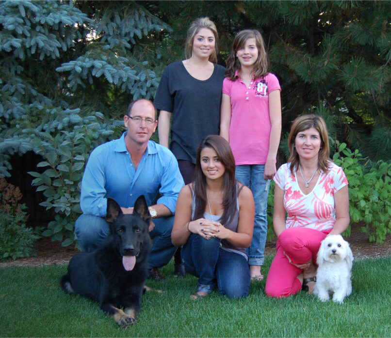 Family sitting on the lawn being protected by their canine protection dog